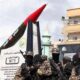 Hamas terrorists displaying a rocket.